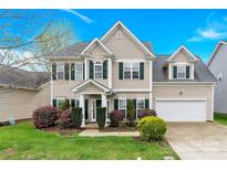 Charming two-story home boasts manicured lawn and lush landscaping at 119 Tilton Dr, Mooresville, NC 28115