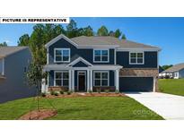 Inviting two-story home with a combination of siding and brick accents, enhanced by a well-manicured front lawn at 134 Asmodean Ln, Troutman, NC 28166