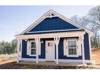 Charming blue cottage with white trim, decorative white posts, and a welcoming front porch at 1432 Blackbird Dr, Clover, SC 29710