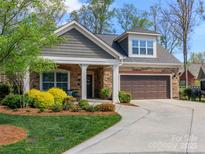 Charming home featuring a manicured front yard, stone and siding exterior, and an attached garage at 2342 Wesley Landing Rd, Waxhaw, NC 28173