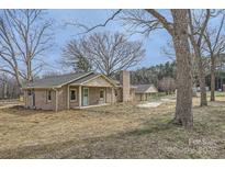 Charming brick home featuring a covered front porch and detached garage at 3225 Liberty Rd, Gold Hill, NC 28071