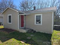 Charming single-story home with light beige siding, a red door, and a neatly landscaped front yard at 325 Orr Dr, Rock Hill, SC 29730