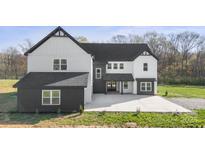 Two-story home with contrasting white and black exterior, gabled roof, and concrete driveway at 3907 E Lawyers Rd, Monroe, NC 28110