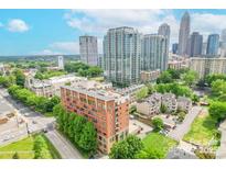 Condo building with city skyline views and mature landscaping at 715 N Church St # 301, Charlotte, NC 28202