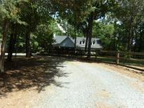 Charming home featuring a long gravel driveway and a welcoming wooden fence at 7218 Alexander Farm Rd, Monroe, NC 28110