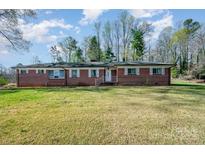 Charming brick home with a lush front lawn and classic white trim at 724 Rocky River W Rd, Charlotte, NC 28213