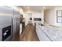 Modern kitchen featuring white cabinetry, granite countertops, stainless steel appliances, and hardwood flooring at 7865 Iron Rd, Sherrills Ford, NC 28673