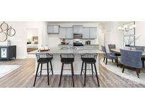 Bright kitchen boasts a large island with barstool seating, light gray cabinetry, and modern finishes at 7869 Iron Rd, Sherrills Ford, NC 28673