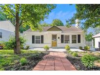 Charming single-story home with a brick pathway, well-manicured lawn, and white picket fence at 813 North Ave, Charlotte, NC 28208