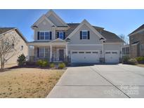 Charming two-story home featuring a three car garage and welcoming front porch at 9007 Raven Top Dr, Mint Hill, NC 28227