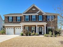 Charming two-story brick home with a three-car garage and well-maintained landscaping at 9937 Travertine Trl, Davidson, NC 28036