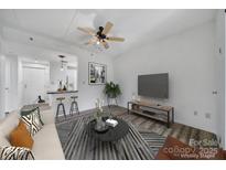 Open-concept living area featuring contemporary decor, a stylish rug, and access to the kitchen and adjacent rooms at 211 Heritage Blvd # 301, Fort Mill, SC 29715