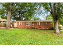 Charming red brick home with mature trees and a well-manicured lawn at 4107 Windwood Dr, Gastonia, NC 28056