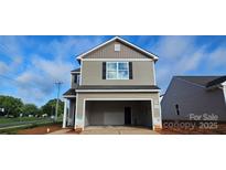 New two-story home featuring an attached garage with neutral siding and black shutters against a bright blue sky at 503 Maddox Dr, Shelby, NC 28152