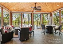 Inviting screened porch with beautiful views of the surrounding trees and lake at 167 Maple View Dr, Troutman, NC 28166