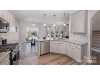 Modern kitchen featuring stainless steel appliances, granite countertops, and a breakfast bar at 16718 Keene Ct, Charlotte, NC 28278