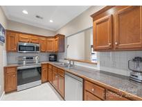 Traditional kitchen with stainless steel appliances and wood cabinetry, offering ample counter space at 2783 Clover Nw Rd, Concord, NC 28027