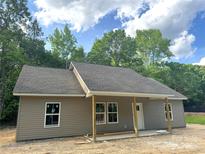 New construction home featuring vinyl siding, covered front porch, and an unfinished yard at 318 Stanback St, Mount Gilead, NC 27306