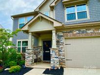 Charming home featuring a stone facade, covered porch, and well-maintained landscaping at 154 Rooster Tail Ln, Troutman, NC 28166