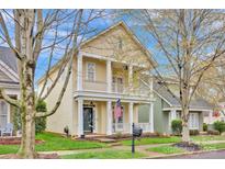 Charming two-story home with a welcoming porch, manicured lawn, and classic architectural details at 16606 Spruell St, Huntersville, NC 28078