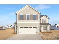 Charming two-story home with a two-car garage, gray siding, and traditional shuttered windows at 32586 Millingport Rd # 7147, New London, NC 28127