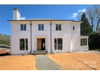 New two-story home featuring a white painted brick facade, classic shutters, and a well-manicured front yard at 3411 Seward Pl, Charlotte, NC 28211
