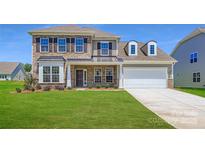 Inviting two-story home showcasing a brick facade, well-manicured lawn, and a two-car garage at 3886 Horsham St, Indian Land, SC 29707