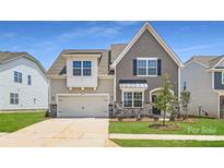 Charming two-story home featuring a two-car garage, stone accents, and manicured lawn at 4171 Skyboat Cir, Fort Mill, SC 29715