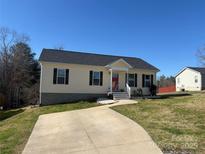 Charming single-story home featuring a well-manicured lawn and a concrete driveway on a sunny day at 52 Restful Ln, Hickory, NC 28601