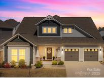 Charming two-story home featuring a two-car garage, stone accents, and a manicured lawn at 7313 Glenroe Dr, Huntersville, NC 28078