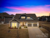 Charming two-story home featuring a landscaped yard, a two-car garage and beautiful lighting at 7313 Glenroe Dr, Huntersville, NC 28078