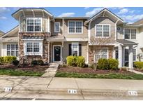 Charming townhome featuring stone accents and manicured landscaping leading to a welcoming front entrance at 816 Gentlewinds Ct, Fort Mill, SC 29708