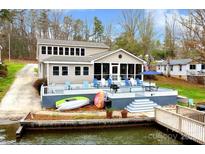 Lakefront home featuring a spacious deck, dock, and easy access to the water at 938 Pinehaven Dr, New London, NC 28127