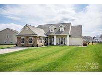 Charming single-Gathering home with stone accents, well-manicured lawn, and a welcoming covered front porch at 118 Heathrow Ln, Statesville, NC 28677