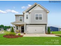 Charming two-story home with a welcoming front porch, manicured lawn, and a two-car garage at 12140 Devon Square Ct, Charlotte, NC 28262