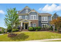 Charming two-story home featuring a landscaped front yard and stone accents at 1276 Stonecrest Blvd, Tega Cay, SC 29708