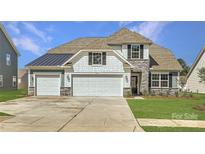 Charming home featuring a three car garage, stone accents, and attractive exterior finishes at 1557 Croydon St, Indian Land, SC 29707