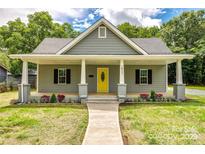 Charming single-Gathering home featuring a welcoming front porch and well-manicured landscaping at 1022 Parker St, Monroe, NC 28112