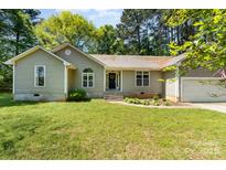 Charming single-story home featuring a well-maintained lawn and attached garage, perfect for suburban living at 2014 Cardinal Loop, Stanley, NC 28164