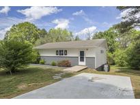 Charming single-story home with a lush yard, a concrete driveway and unique architectural details at 2403 Earley Cir, Kannapolis, NC 28083