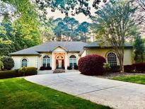 Elegant ranch home featuring manicured landscaping, a circular driveway and arched windows at 2587 Penngate Dr, Sherrills Ford, NC 28673