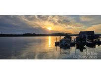 Beautiful waterfront property with boat dock featuring serene lake views at sunset at 2587 Penngate Dr, Sherrills Ford, NC 28673
