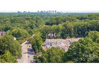 Scenic aerial view of charming townhomes surrounded by lush greenery and the city skyline in the distance at 3111 Everly Enclave Way, Charlotte, NC 28210
