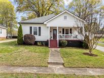 Charming home featuring a covered front porch and a well-maintained lawn at 405 E 3Rd St, Kannapolis, NC 28083