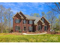 Stately two-story red brick home featuring classic architectural design and professionally landscaped front yard at 420 Woodlark Ct, Indian Trail, NC 28079