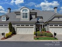 Beautiful two-story home featuring a three-car garage and well-maintained landscaping under a blue sky at 8015 Greenview Terrace Ct, Charlotte, NC 28277