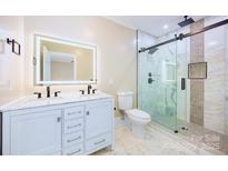 Bright bathroom features a modern vanity with LED mirror and walk-in shower with glass enclosure at 1132 E Main St, Albemarle, NC 28001