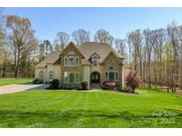 Stately home boasts a manicured lawn, stone accents, and a grand entrance, all bathed in sunlight at 2017 Colorado Ct, Lancaster, SC 29720