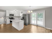 Modern kitchen features stainless steel appliances, white cabinets and island, and a sliding glass door at 2220 Ross Cauthen Rd, Lancaster, SC 29720