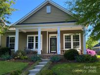 Charming home featuring a quaint covered front porch and well-manicured landscaping at 353 Montibello Dr, Mooresville, NC 28117